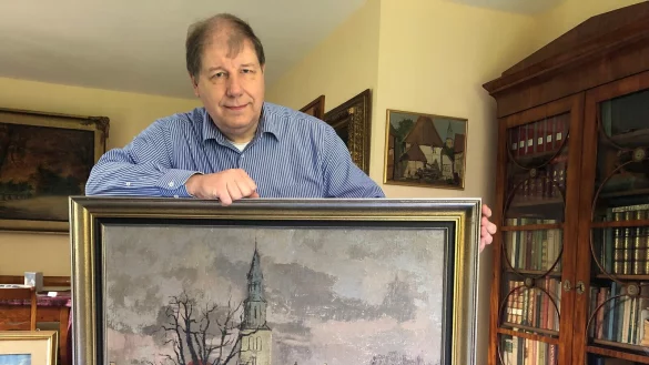 Historiker Stefan Wiesekopsieker mit einem Bild von Richard Sprick. Die Schötmaraner Kilianskirche ist häufig Mittelpunkt der Bilder des Malers. - © Sven Kienscherf