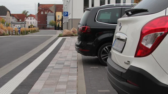 Wer am Rathaus parkt, muss den Gehweg frei lassen. Das wei&szlig;e Auto steht richtig. Der schwarze Kombi riskiert ein Kn&ouml;llchen, da er auf den schmalen Gehweg ragt. - &copy; Dieter Asbrock