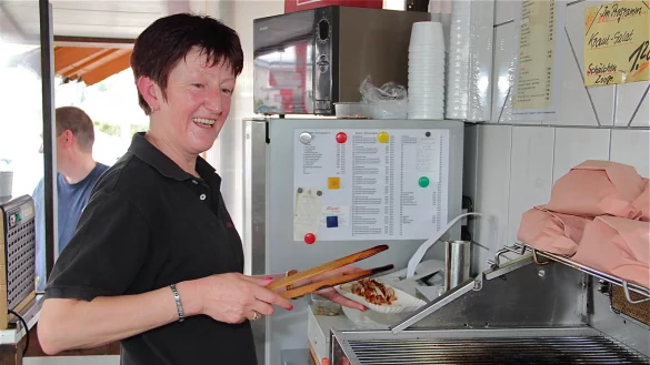 Schweisstreibender Job: Wenn Lena Schmidtke die Würstchen wendet, gibt es immer einen flotten Spruch gratis. Die Menü-Wünsche ihrer Stammkunden hat sie alle im Kopf. - © Heidi Stork