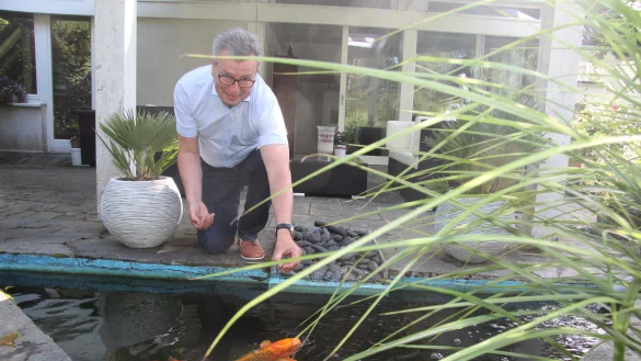 Ein seltener Moment des M&uuml;&szlig;iggangs: Jens Gnisa in seinem Garten. Ein Ort zum Verweilen mit Kois, Tomatenstauden, Sitzecken f&uuml;r jeden Sonnenstand. - &copy; Martin Hostert