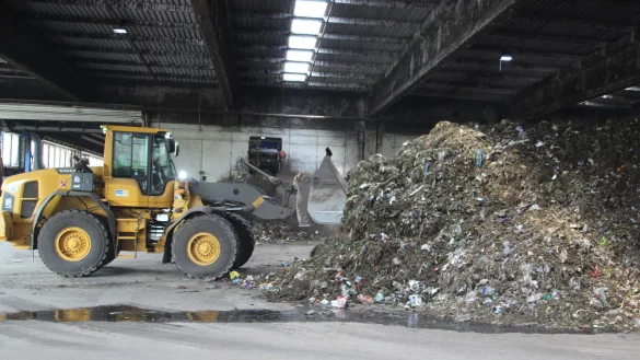 Auf der Deponie Maibolte wird Laub mit anderem Biomüll vermischt, am Ende wird daraus Kompost. Hier schiebt ein Radler den Abfall auf den Haufen. Gut zu erkennen sind die Plastiktüten, die ein massives Problem darstellen - © Till Brand