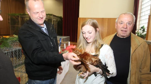 Auszeichnete Tiere: Damo Krieger zeigt Nina Wienbröker und Wolfgang Oettermann (von links) ein prämiertes Chabo Huhn. - © Daniel Hobein