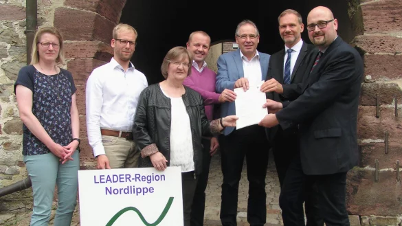 Die Regionalmanager Diana Rieke und Borris Ortmeier sowie die vier B&uuml;rgermeister Monika Rehmert, Mario Hecker, Friedrich Ehlert und J&uuml;rgen Schell nehmen den F&ouml;rderbescheid von Konstantin Pl&uuml;mer von der Bezirkregierung entgegen (von links). - &copy; Wulf Daneyko