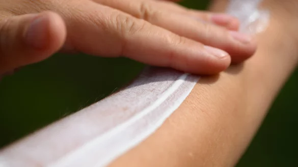 Eine Person tr&auml;gt Sonnencreme auf die Haut auf &ndash; neue EU-Regelungen k&ouml;nnten die Beschr&auml;nkungen f&uuml;r krebserregende Stoffe in Kosmetika lockern. - &copy; Robert Michael/dpa