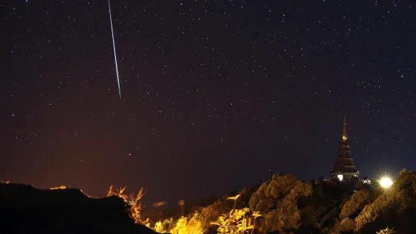 Die Geminiden am Nachthimmel &uuml;ber den Pagodend&auml;chern von Chiang Mai in Thailand. Im Sternbild der Zwillinge kann man zurzeit vermehrt Sternschnuppen beobachten. - &copy; dpa