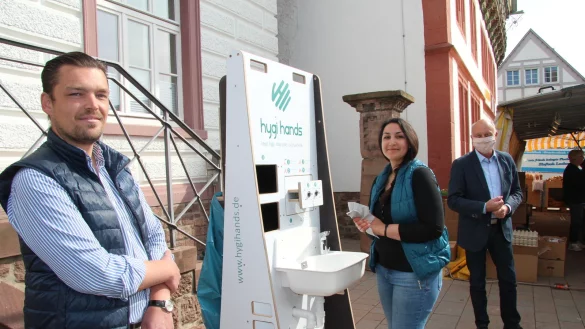 Der Blomberger Falk Trompeter (links) hat zusammen mit vier Partnern eine mobile Waschstation erfunden. Hygihands geht in Serie. Der Stadt Blomberg schenkte das Startup CIS acht Stationen. Eine davon soll nun jeden Tag am Marktplatz allen B&uuml;rgern zur Verf&uuml;gung stehen. Die Station findet Sabra Demir super. Auch B&uuml;rgermeister Klaus Geise freut sich &uuml;ber die Spende. - &copy; Seda Hagemann