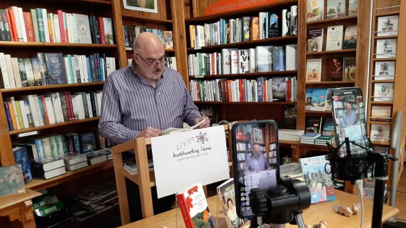 Joachim H. Peters liest vor zwei Smartphones, die die Lesung live in social-media-Kan&auml;le &uuml;bertragen. - &copy; J&ouml;rg Czyborra