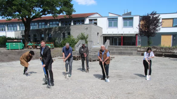 Antreten zum symbolischen Spatenstich: Sch&uuml;lersprecher Adam Ramadani, B&uuml;rgermeister Dr. Andreas Wulf, Landschaftsarchitekt Bruno Peters, der Vertreter des Landschaftsbau-Betriebes, Herr Zimmermann, Bauausschussvorsitzender Wolfgang Holitschke sowie Sch&uuml;lersprecherin Saadet Sarioglu (von links) k&ouml;nnen den geschotterten Untergrund des Pausenhofes kaum durchdringen. - &copy; Dieter Asbrock