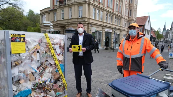 B&uuml;rgermeister Frank Hilker (links) zeigt eine der City-Cards, die mit Motto-Spr&uuml;chen bedruckt sind. Der Inhalt der Skulptur stammt aus Detmolder Stra&szlig;engr&auml;ben. Frank Heuman von der Stadtreinigung sammelt immer mehr Masken ein: 40 St&uuml;ck pro Schicht. - &copy; Sven Koch