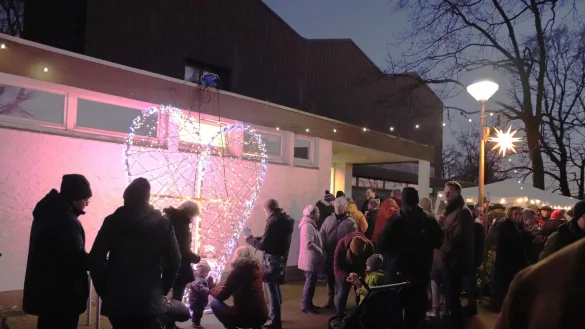 Vor der Kirche suchten 350 B&uuml;rgerinnen und B&uuml;rger aus Lipperreihe das Gespr&auml;ch miteinander. Das Symbol des Treffens, ein gro&szlig;es, beleuchtetes Herz, hatte Marco Regenhardt, Besitzer des Lichterhauses hergestellt. Foto: Knut Dinter - &copy; Knut Dinter