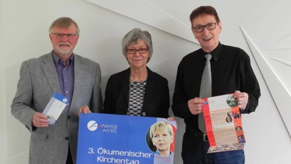 Pfarrer i.R. Rolf-Joachim Krohn-Grimberghe, Kirchentagsbeauftragter der Lippischen Landeskirche, Birgit Pötzsch, Pfarrerin im Landeskirchenamt für den 3. ÖKT in Lippe, und Fritz Tibbe, Geschäftsführer des 3. ÖKT in Lippe, präsentieren die Plakate und Programm-Flyer. - © privat