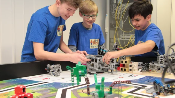 Die Teammitglieder von Le(m)go Bricks (von links) Jannick Ahlvers (15), Hendrik Hanke (11) und Tarek Gr&ouml;ne (13) arbeiten an dem von ihnen entworfenen, gebauten und programmierten Roboter. Mit ihm sind sie beim Wettbewerb "First Lego League" angetreten. - &copy; Carolin Brokmann-F&ouml;rster