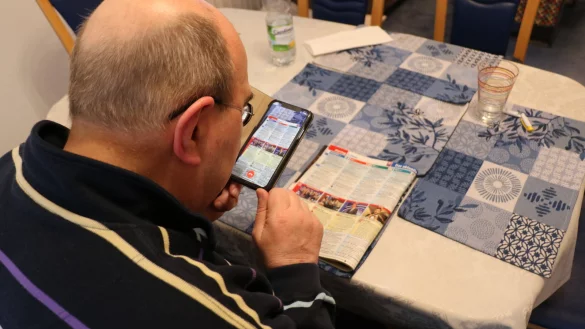 Manfred Moses probiert die App &bdquo;Be My Eyes" aus. &Uuml;ber das Bild der Kamera kann ein zuf&auml;llig vermittelter, freiwilliger Helfer dem Sehbehinderten bei einer allt&auml;glichen Aufgabe helfen &ndash; zum Beispiel beim Lesen des Fernsehprogramms. - &copy; Till Sadlowski