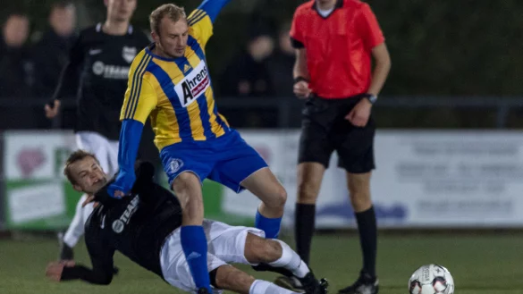 Konsequenter Einsatz - Der Jerxer Magnus Diekmann (schwarz, links) gr&auml;tscht gegen den L&uuml;gder Kris Pape (gelb, rechts) vor den Augen des Schiedsrichters Jan Ole Kr&uuml;ger (rot) den Ball weg. Foto: Egon Penner - &copy; Egon Penner