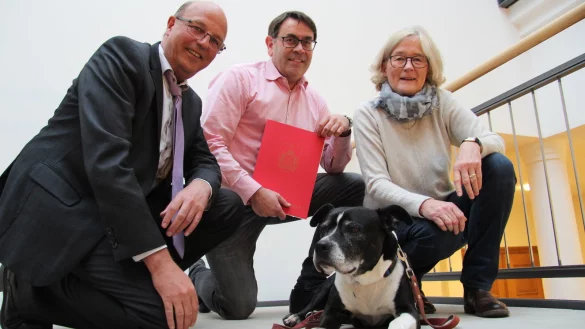Den Vertrag in der Hand: (von links) Rainer Heller, Christopher Imig und Gisela Brinkforth-Pekoch freuen sich gemeinsam mit Hündin Leyla über die Zuwendung der Stadt Detmold. - © Nadine Uphoff