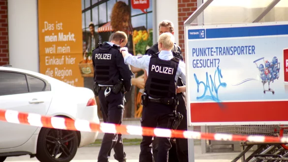 Die Polizeikr&auml;fte besprechen den Einsatz vorm Rewe-Markt. - &copy; Niklas Kr&auml;mer