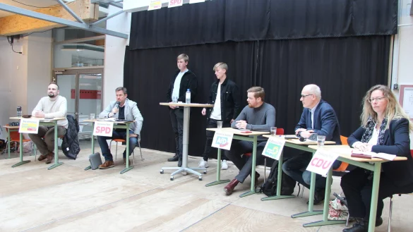 Die Sch&uuml;ler Haakon Herrmuth und Daniel Ridderbusch (stehend von links) moderieren die Podiumsdiskussion. Mit dabei sind Nils Allersmeier (FDP, von links), Alexander Baer (SPD), Maximilian Kneller (AfD), Dr. Burkhard Pohl (Gr&uuml;ne) und Christiane Thiel (CDU). Nicolai Kinder von den Linken konnte wegen Krankheit nicht teilnehmen. - &copy; Kirsten Fuhrmann