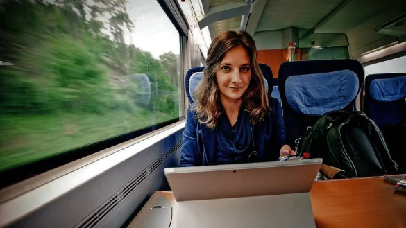 Dauerreisende: Die in Bielefeld aufgewachsene Leonie M&uuml;ller sitzt in derBahn an ihrem Laptop auf der Strecke zwischen K&ouml;ln und Stuttgart. Daneben im Rucksack hat sie die n&ouml;tigsten Dinge zum Leben. In T&uuml;bingen, K&ouml;ln und Berlin warten ein paar Wechselklamotten. - &copy; Felix Mayr
