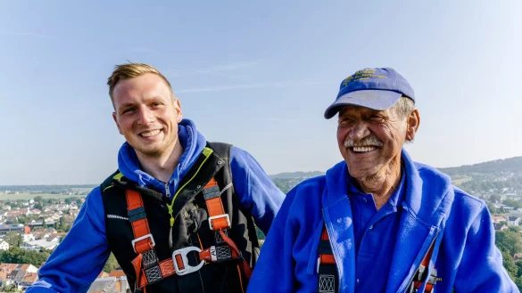 Gregor B&auml;umer (rechts) ist sichtlich entspannt &ndash; trotz der luftigen H&ouml;he am Kirchturm von St. Nicolai. Dort arbeitete er im Juni 2019 zusammen mit Dachdeckermeister Marius Louvet. Jetzt geht B&auml;umer in den Ruhestand. - &copy; Nicole Reineke