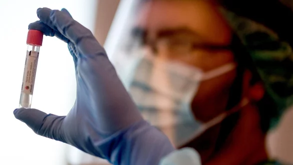 Ein Arzt h&auml;lt einen Corona-Test - &copy; Foto: Britta Pedersen/dpa-Zentralbild/dpa