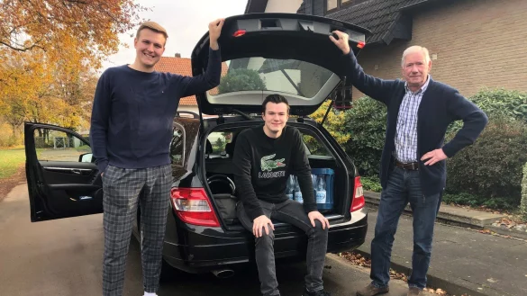 Timo und Nils Schlingmann stehen mit ihrem Gro&szlig;vater Peter Samland (von links) am Auto. Die beiden Br&uuml;der bieten an, f&uuml;r Menschen in Holzhausen-Sylbach, die zur Corona-Risikogruppe geh&ouml;ren, das Einkaufen zu &uuml;bernehmen. - &copy; Sven Kienscherf