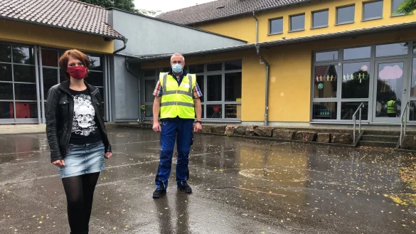 Schulleiterin Stefanie L&ouml;sing und Haustechniker Peter B&uuml;the stehen auf dem Schulhof. Sie haben eine vor&uuml;bergehende Sondergenehmigung, aber heute Nachmittag m&uuml;ssen auch sie zun&auml;chst in h&auml;usliche Quarant&auml;ne, zumindest bis ihr Testergebnis feststeht. - &copy; Sven Kienscherf