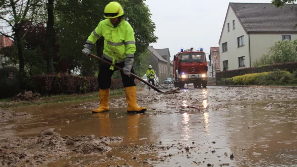 Inzwischen schon ein vertrautes Bild: Einsatzkr&auml;fte der Kalletaler Feuerwehr schaufeln am 30. April 2014 die bei Starkregen &uuml;berschwemmte Ortsdurchfahrt Bentorf frei. - &copy; Jens Rademacher