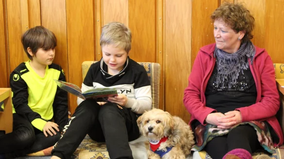 Hündin Jule darf sich entspannen, während Lina und Florian (beide 8) mit Anne Junker gemeinsam lesen. - © Lorraine Brinkmann