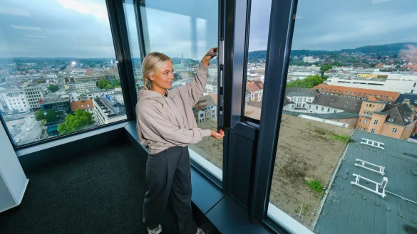 Gigantischer Blick &uuml;ber die Stadt und moderne Technik: NW-Praktikantin Lina Marie Baatz ist beeindruckt von der Aussicht in der elften Etage und l&auml;sst durch ein kleines Fenster frische Luft ins B&uuml;ro. - &copy; Andreas Zobe
