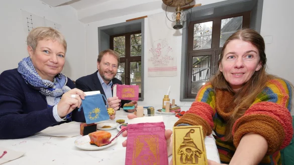 Probieren den Textildruck aus: Katharina Schlimmgen, Professor Dr. Jan Carstensen und Ulrike Loth (von links) testen eine der Mitmach- Aktionen des Museumsadvents. Ulrike Loth hält eine der Formen in die Kamera, mit denen die Kinder drucken können. - © Jost Wolf