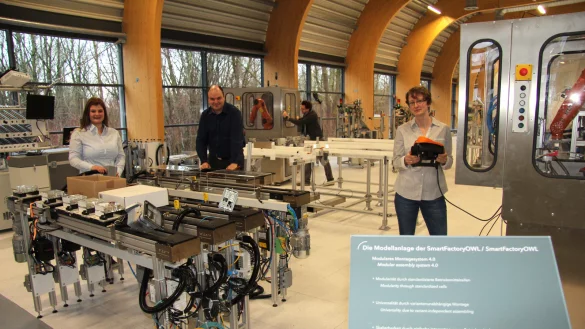 In der intelligenten Fabrik der Zukunft: (von links) Melissa Paris, Benedikt Lücke, Sascha Heymann (im Hintergrund) und Andrea Huxol bereiten die einzelnen Module für die Inbetriebnahme vor. - © Thomas Reineke
