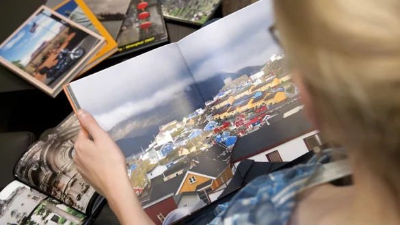 Eine Frau schaut sich ein Fotobuch an - &copy; Foto: Mascha Brichta/dpa-tmn