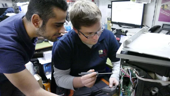 Lernen von dem Besten: Amjad Al Hamwi (links) schaut seinem Kollegen Matthias Koch bei der Reparatur eines Kaffeevollautomaten &uuml;ber die Schulter. - &copy; Achim Krause