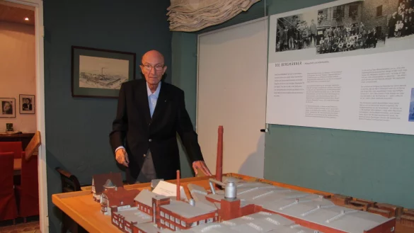 Der ehemalige Firmeninhaber Gustav Bergmann in seinem kleinen Museum, wo er auch ein Modell des Fabrikgeländes in Kachtenhausen aus dem Jahr 1938 stehen hat, das Mitarbeiter angefertigt haben. Das Modell stammt von Innenarchitekt Ernst Erzbächer.  - © Cordula Gröne