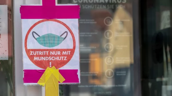 Ein Hinweisschild zeigt am Eingang eines Restaurants, dass der Zutritt nur mit Mund-Nasen-Schutz erlaubt ist. Das Saarland will mit dem Ausstieg aus dem Lockdown beginnen. - &copy; Harald Tittel/dpa