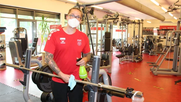 Nico Zickel, Studioleiter des "TeVita", zeigt, wie jeder Trainierende nach die Ger&auml;te nach Benutzung mit einem Microfaser-Tuch desinfiziert. - &copy; Sandra Castrup