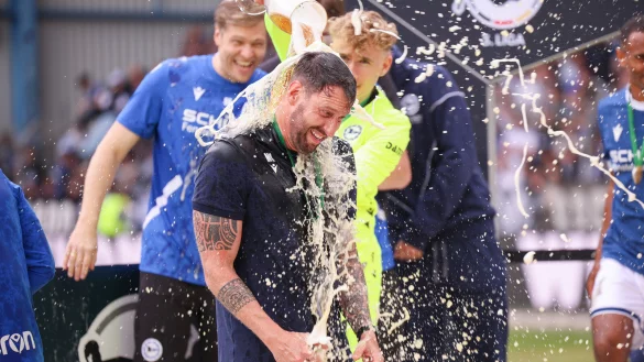 Volltreffer: Arminia-Keeper Jonas Kersken verpasst seinem Trainer Mitch Kniat eine Bierdusche. - &copy; Oliver Krato