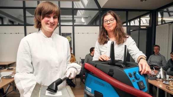 Multitalent: Friederike Nithack (links) und Birgit Geller von der LWL-Restaurierungswerkstatt zeigen den lippischen Archivaren das neue Arbeitsger&auml;t &ndash; einen Staubsauger mit ganz besonderen F&auml;higkeiten. - &copy; Torben Gocke