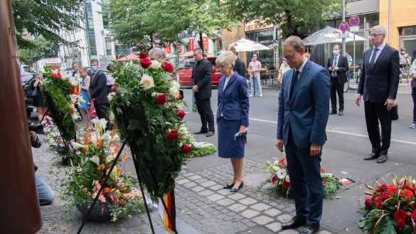 Der Regierende B&uuml;rgermeister Michael M&uuml;ller (SPD,r) mit Verlegerin Friede Springer am Peter-Fechter-Gedenkort in der Zimmerstra&szlig;e. Dort gedachten zahlreiche Menschen den Bau der Berliner Mauer vor 59 Jahren. - &copy; Paul Zinken/dpa