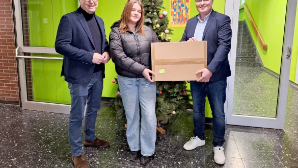 Marc Thiel (links, Geschäftsführung Lippe Bildung eG) und Thomas Mahlmann (zdi-Zentrum
Lippe.MINT) übergeben Mila Hauser den Hauptpreis. - © Lippe Bildung eG