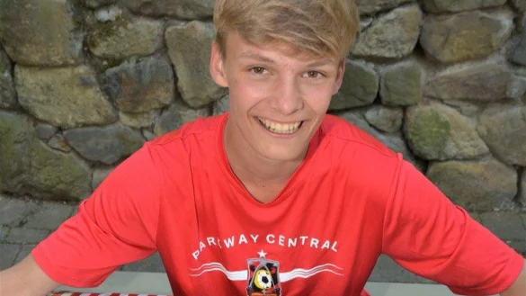 Nelson Worm (15), Sch&uuml;ler des Niklas-Luhmann-Gymnasiums, tr&auml;gt das rote Shirt der Parkway Central Highschool. Vor ihm liegen symbolisch amerikanische Flaggen. - &copy; Karin Prignitz