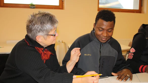 Noch ganz am Anfang: Martina Rudolphi, die zur Kontaktgruppe geh&ouml;rt, hilft Draman Sanouno seine ersten deutschen Worte aus Papier zu bringen. - &copy; Freya K&ouml;hring