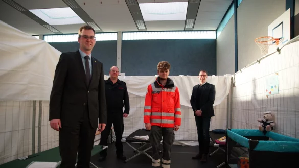 B&uuml;rgermeister Matthias Kalkreuter (links) und Diemo D&ouml;lle von der Stadt (rechts) bedanken sich bei Wehrf&uuml;hrer Benjamin Brinkmeyer (Zweiter von links) und Elias K&uuml;bler vom Deutschen Roten Kreuz f&uuml;r den Aufbau in der Sporthalle am Werreanger. - &copy; Stadt Lage