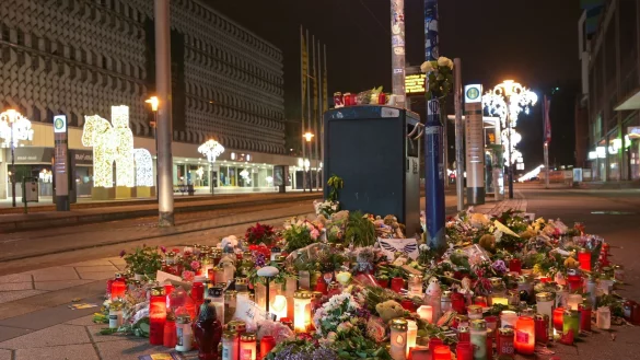 Blumen und Kerzen stehen im Gedenken an die Anschlagsopfer an einer Stra&szlig;enbahnhaltestelle in Magdeburg. - &copy; Heiko Rebsch/dpa
