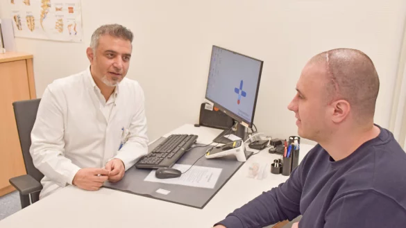 Während der Nachsorge untersucht der Paderborner Neurochirurg Abdulhannan Alaboud die künstliche Schädeldecke seines Patienten Pavlo L., der bald wieder arbeiten will. - © Brüderkrankenhaus St. Josef