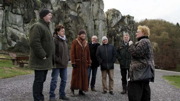 Gästeführerin Cornelia Müller-Hisje (rechts) führt Bürgermeister Stefan Rother, Petra Kirschke (Denkmal-Stiftung Landesverband Lippe), Verbandsvorsteherin Anke Peithmann, die Geschäftsführer der Denkmal-Stiftung, Klaus Stein und Ralf Noske, sowie Forstdirektor Hans-Ulrich Braun (von links) durch das Areal und erläutert die Natur- und Kulturgeschichte der Externsteine. - © Privat