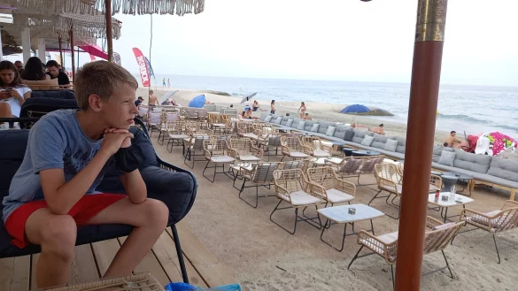 Leonard M&uuml;ller sitzt am Strand auf Korsika. Hier w&auml;re noch Platz f&uuml;r weitere Touristen gewesen, die wegen der Einstufung als Hochrisikogebiet aber ausbleiben. Wegen dieser musste sich der 12-J&auml;hrige nach der Heimreise in Quarant&auml;ne begeben. - &copy; Ulrich M&uuml;ller