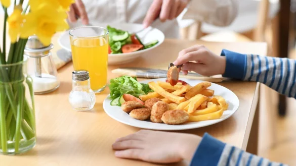 Ein Teller mit Chicken-Nuggets und Pommes auf einem Tisch. - &copy; Foto: Tobias Hase/dpa/dpa-tmn