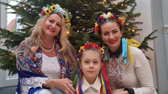 Mit traditionellen Blumenkranz im Haar posieren (von links) Svitlana Hranova, die sechsj&auml;hrige Daria und Marina Safronova vor dem Weihnachtsbaum. Eigentlich werden Heiligabend und Weihnachten am 6. und 7. Januar gefeiert, doch die meisten Ukrainer wollen in diesem Jahr am 24. Dezember Heiligabend feiern. - &copy; Carolin Brokmann-F&ouml;rster