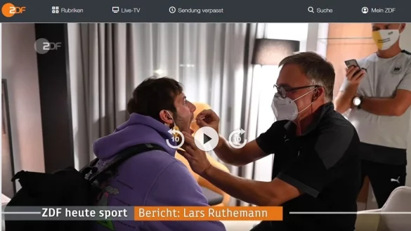 Die entscheidende Szene aus dem ZDF-Beitrag &uuml;ber die deutsche Nationalmannschaft in den Heute-Nachrichten vom 3. November: DHB-Teamarzt Dr. Kurt Steuer entnimmt Uwe Gensheimer eine Speichelprobe. Dabei tr&auml;gt der Mediziner lediglich eine Maske. Schutzbekleidung, Gesichtsvisier und Handschuhe sind nicht zu sehen. Screenshot: MT - &copy; Screenshot Marcus Riechmann